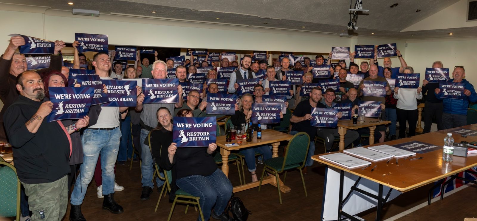 A packed room at the first Bolton branch meeting holding Restore Britain placards